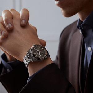 Sophisticated individual showcases a stylish stainless steel watch and elegant attire in a thoughtful pose.