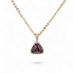 Elegant gold necklace featuring a triangular purple gemstone pendant with diamond accents.