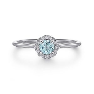 Elegant blue gemstone ring with diamond halo, perfect for engagement or special occasions.
