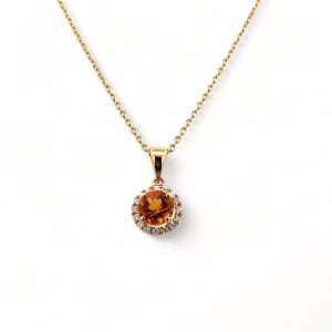 Elegant orange gemstone pendant necklace with diamond accents on a gold chain, perfect for any occasion.
