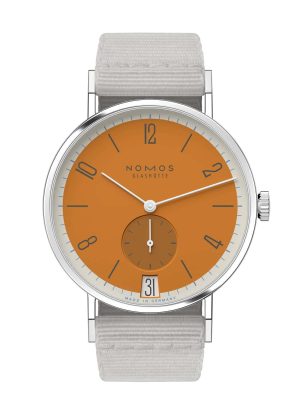 NOMOS Glashütte watch features an orange dial, stainless steel case, and grey fabric strap.