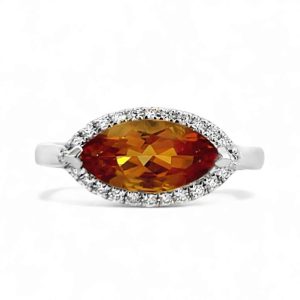 Stunning marquise orange gemstone ring with diamond halo in polished white gold.