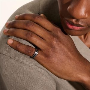 Close-up of a hand on shoulder, showcasing unique skin tones and an elegant ring.